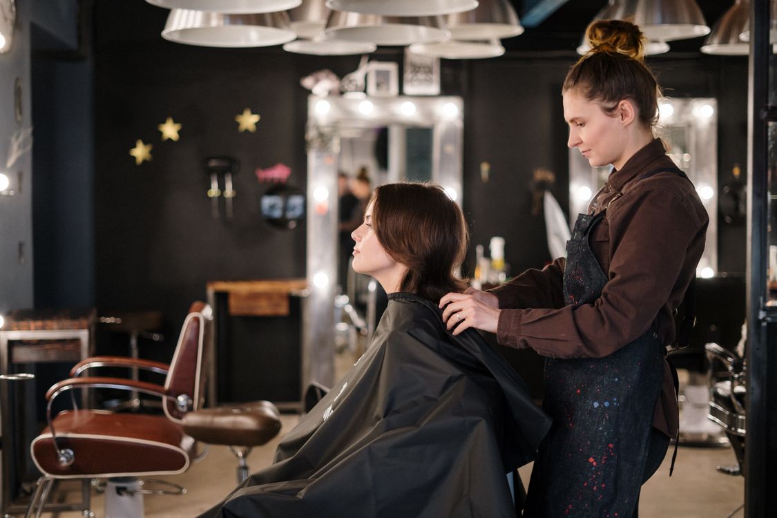 Stylist cutting layers into a client's hair in a modern salon